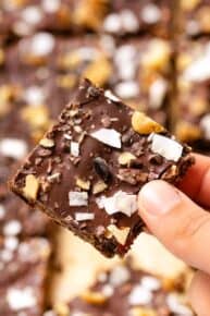 Chocolate quinoa bars with visible oats and nuts, cut into squares and stacked.
